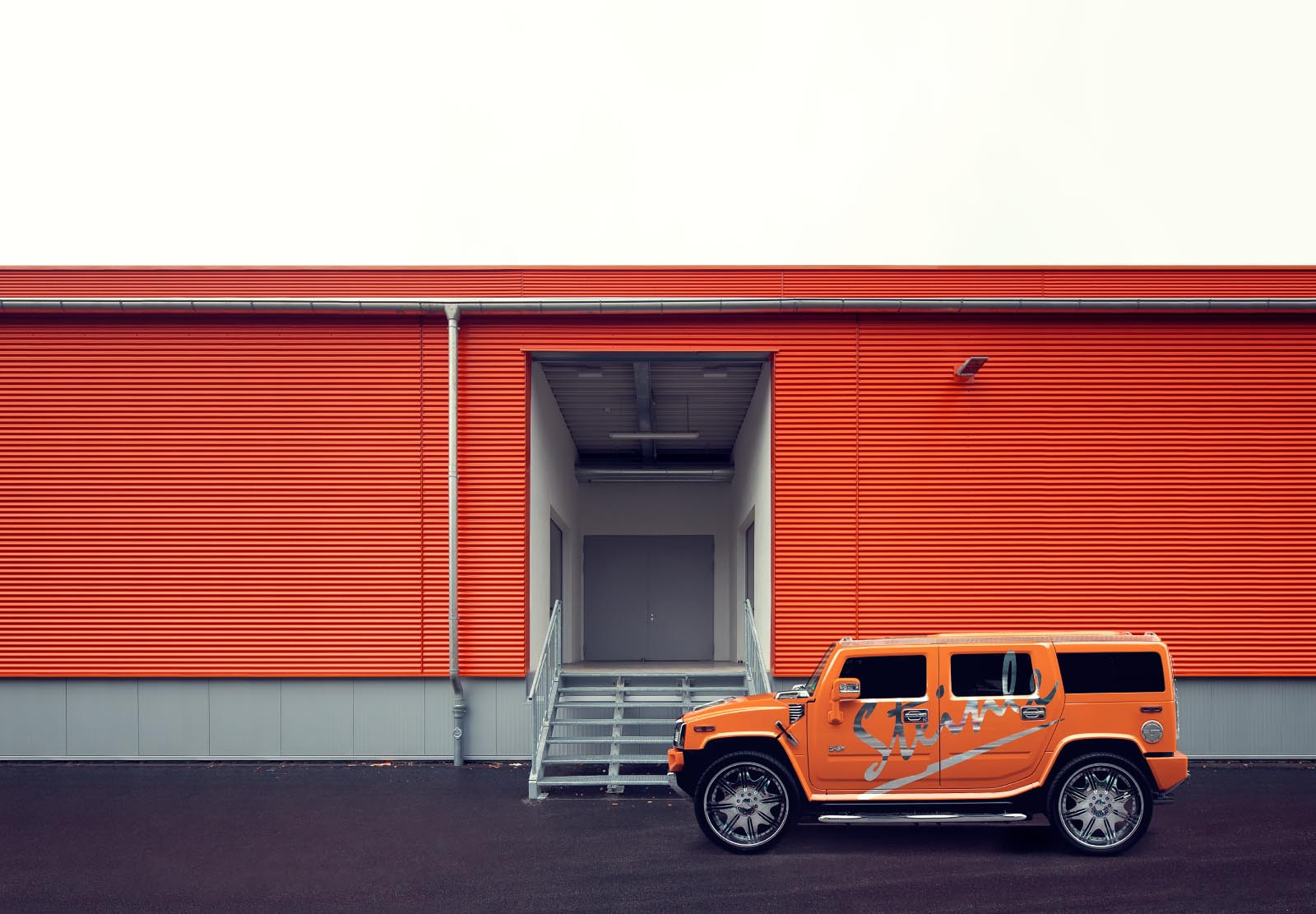Oranger Hummer vor Oranger Fassade