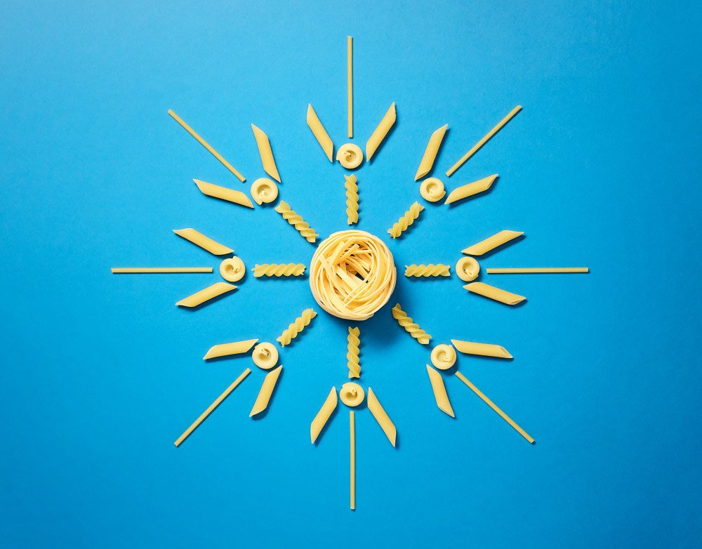 Noodles on blue background aligned to a pattern that forms the sun