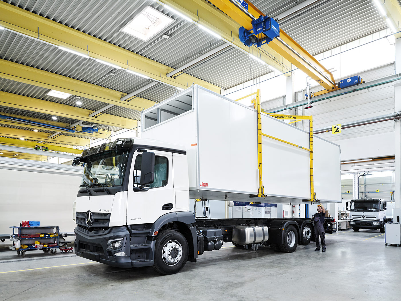 LKW bei der Installation eines KĂĽhlaufbaus in einer Produktionsanlage