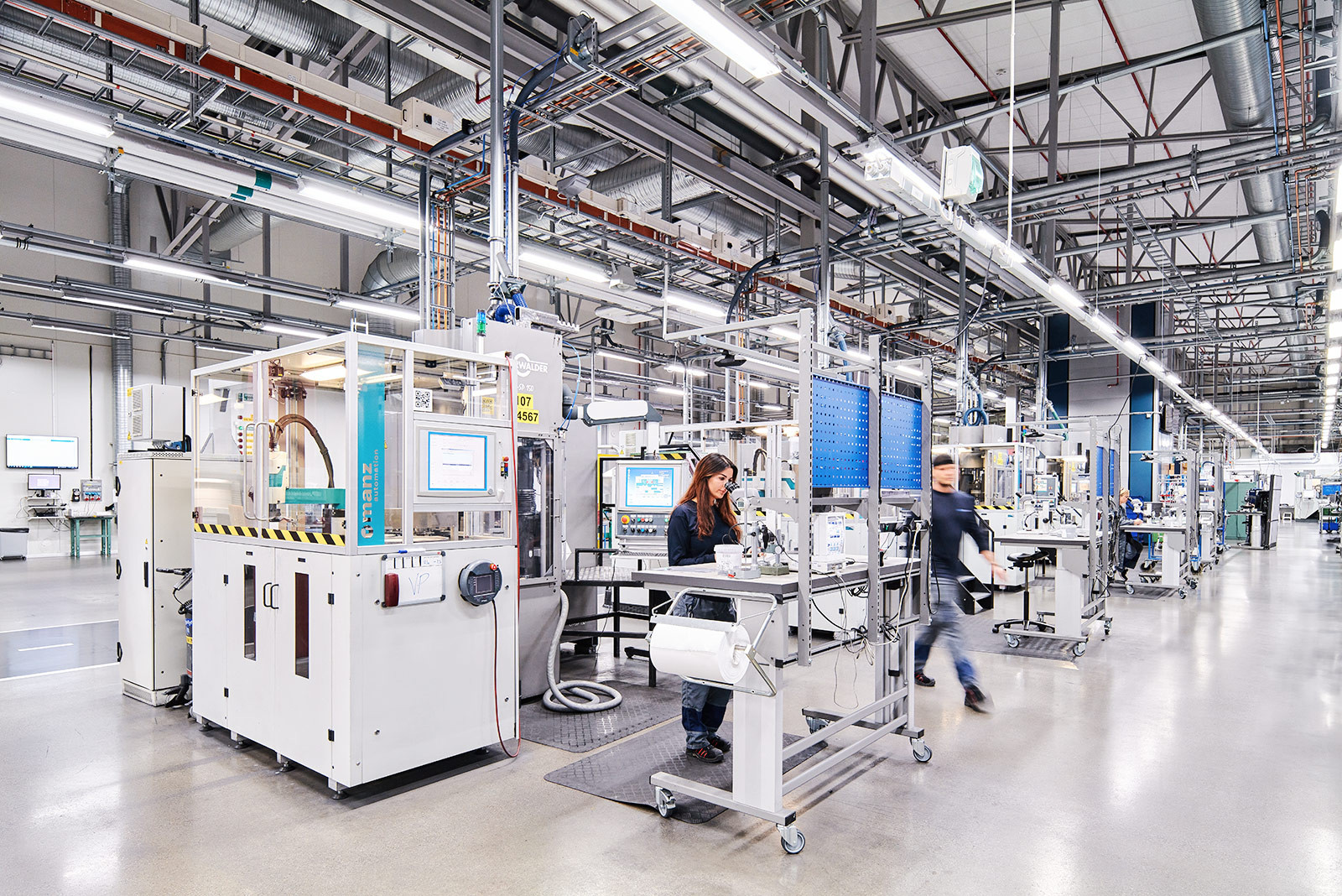 Produktionsstätte bei SCEO Tools in Schweden. Frau blickt in Mikroskop und kontrolliert die Qualität