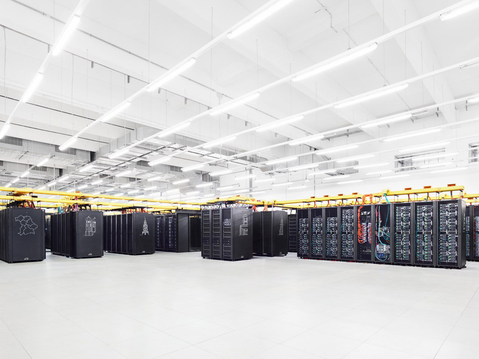 Rows of computers in a large computer room, featuring a vibrant color palette with light black and yellow, dark sky-blue and red tones.