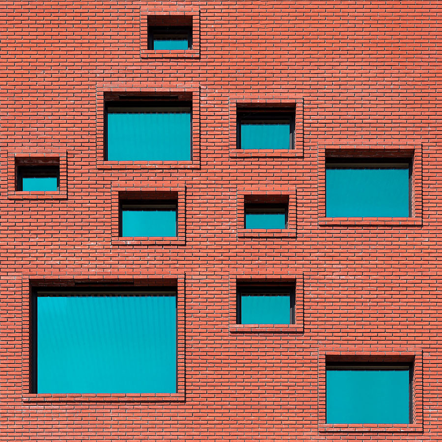 Rotes Ziegelgebäude mit ungewöhnlicher Anordnung der Fenster