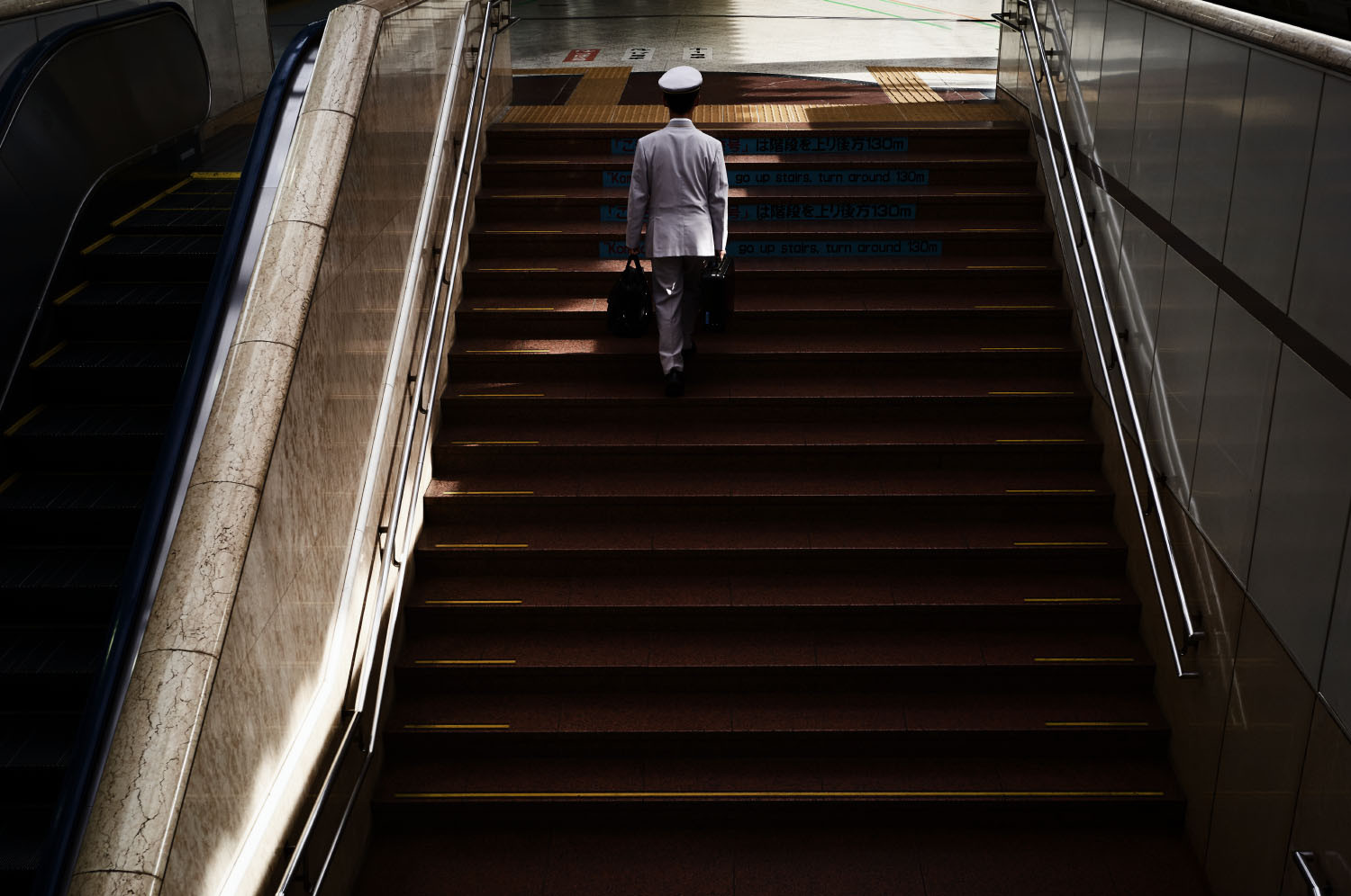 Polizist der die Treppe der Bahnstation in Fukushima hinausgeht