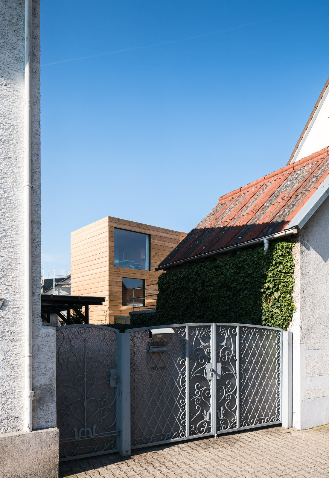 Blick auf den Neubau hin, über ein anderes Haus hinweg