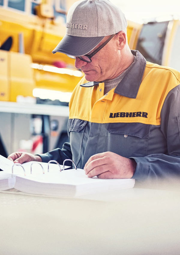 Liebherr Mitarbeiter liest Service-Katalog